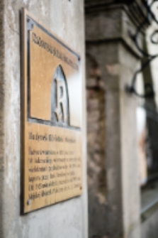 Tablica informacyjna na słupie bramy głównej